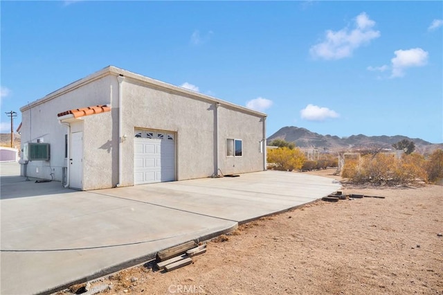 back of property with a garage and a mountain view