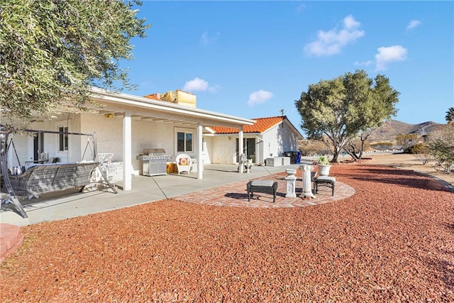 back of house featuring a mountain view and a patio