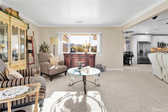 living room featuring ceiling fan, light carpet, and ornamental molding