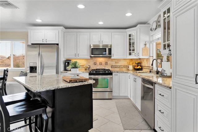 kitchen featuring sink, white cabinets, a center island, and stainless steel appliances