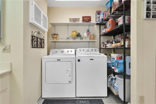 washroom with washer and dryer and light tile patterned floors