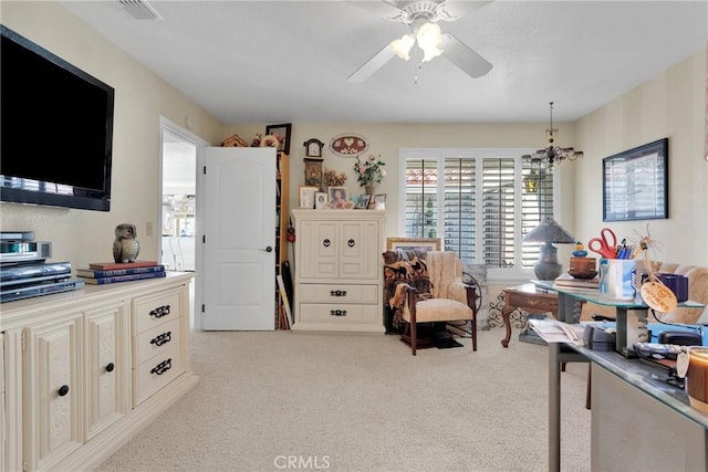 carpeted office with ceiling fan with notable chandelier