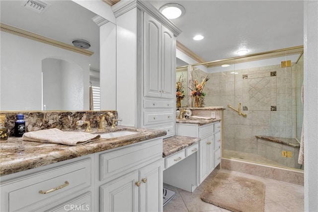 bathroom with walk in shower, crown molding, vanity, and tile patterned flooring