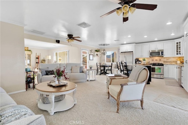 living room with ceiling fan and ornamental molding