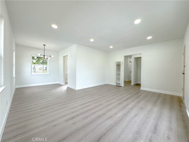 unfurnished room featuring light hardwood / wood-style flooring and a notable chandelier