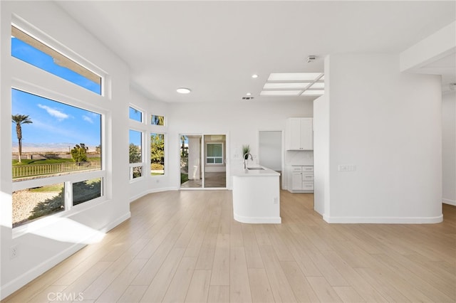 kitchen featuring light wood-type flooring, white cabinets, and sink