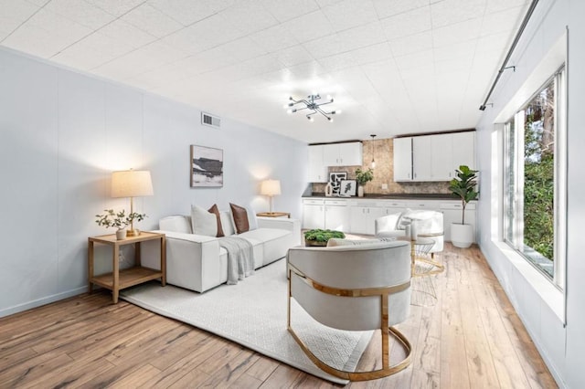 living room featuring a chandelier and light hardwood / wood-style floors