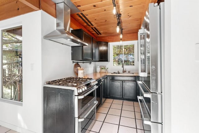 kitchen with appliances with stainless steel finishes, sink, island range hood, light tile patterned flooring, and wooden ceiling