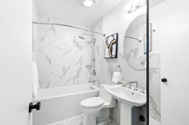 bathroom with toilet, tiled shower / bath, and tile walls