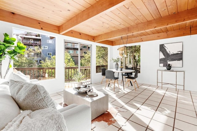 sunroom with wooden ceiling, plenty of natural light, beam ceiling, and a notable chandelier