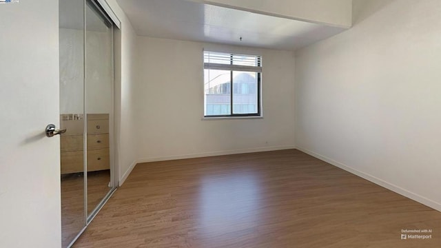 unfurnished bedroom featuring wood-type flooring and a closet