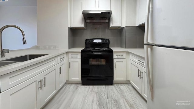 kitchen with white fridge, decorative backsplash, sink, black electric range oven, and white cabinets