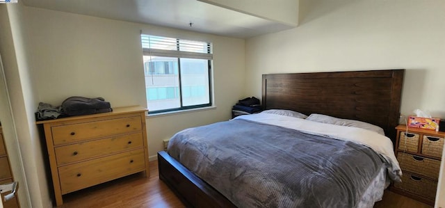 bedroom with dark hardwood / wood-style flooring