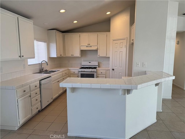 kitchen featuring white cabinetry, kitchen peninsula, tile counters, white appliances, and sink