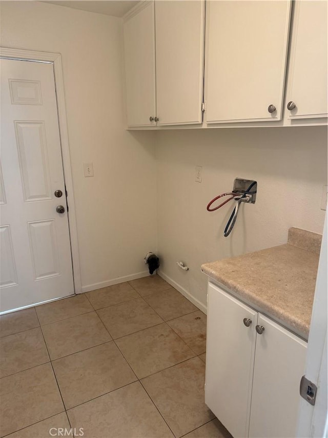 laundry area featuring cabinets, light tile patterned floors, and hookup for a washing machine