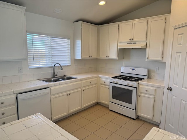 kitchen featuring white appliances, sink, tile countertops, and white cabinetry