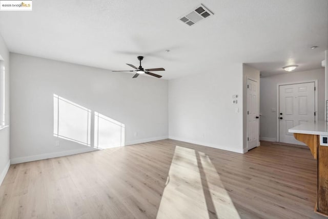 unfurnished living room with ceiling fan and light hardwood / wood-style flooring