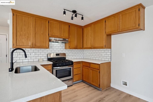 kitchen featuring sink, backsplash, light hardwood / wood-style flooring, and stainless steel range with gas stovetop