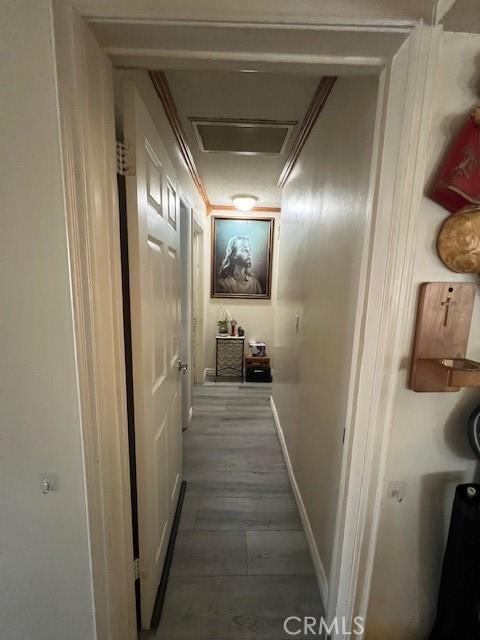 corridor featuring wood-type flooring and crown molding