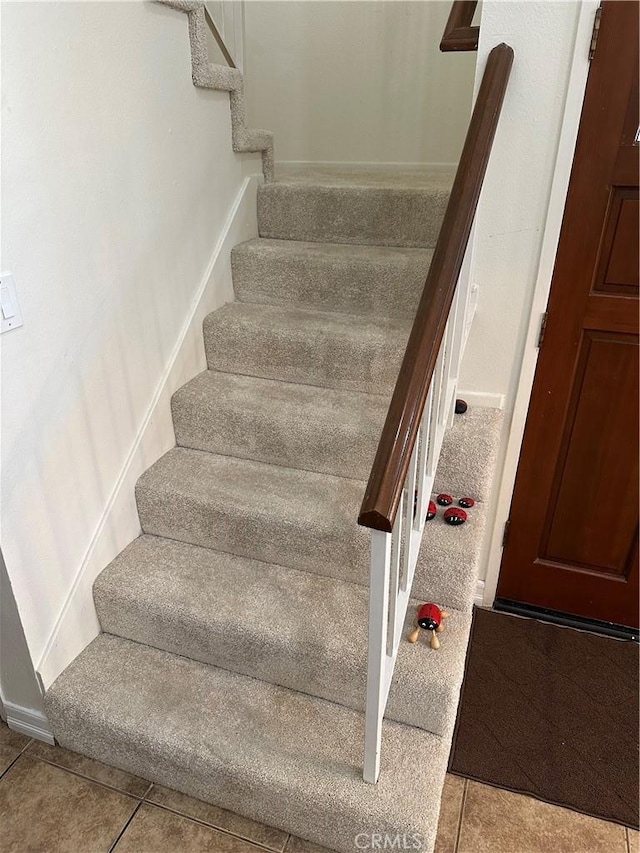 stairway with tile patterned floors