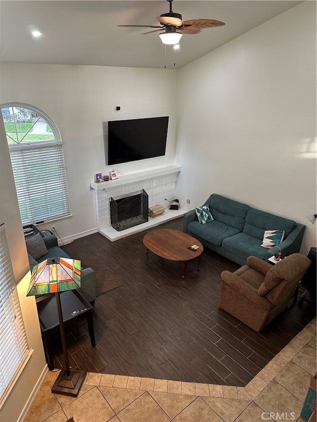 living room featuring hardwood / wood-style floors, ceiling fan, and a fireplace