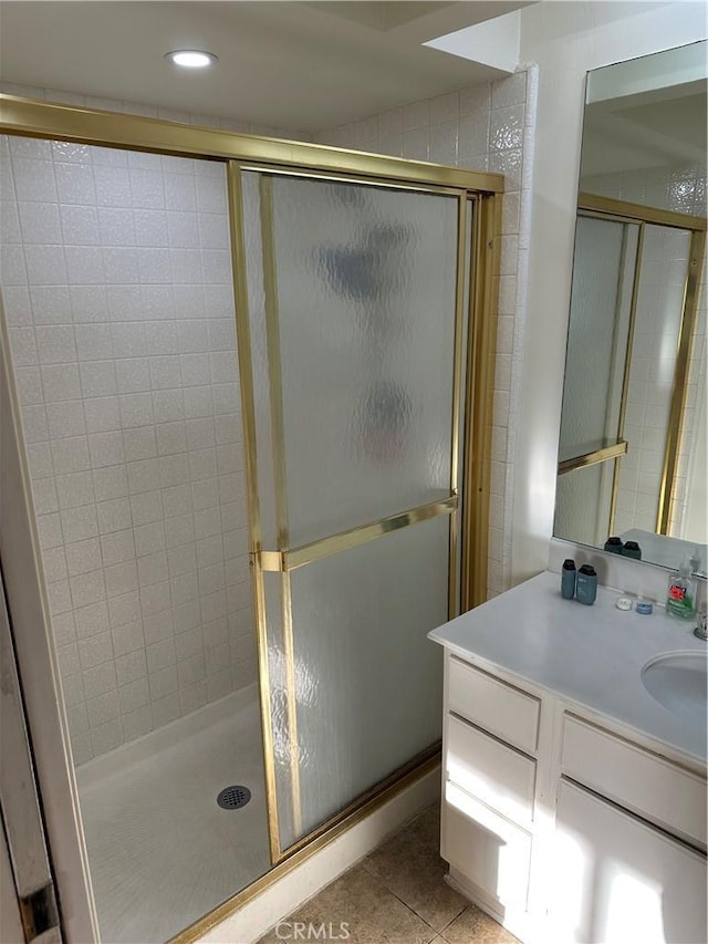 bathroom featuring tile patterned floors, vanity, and a shower with door