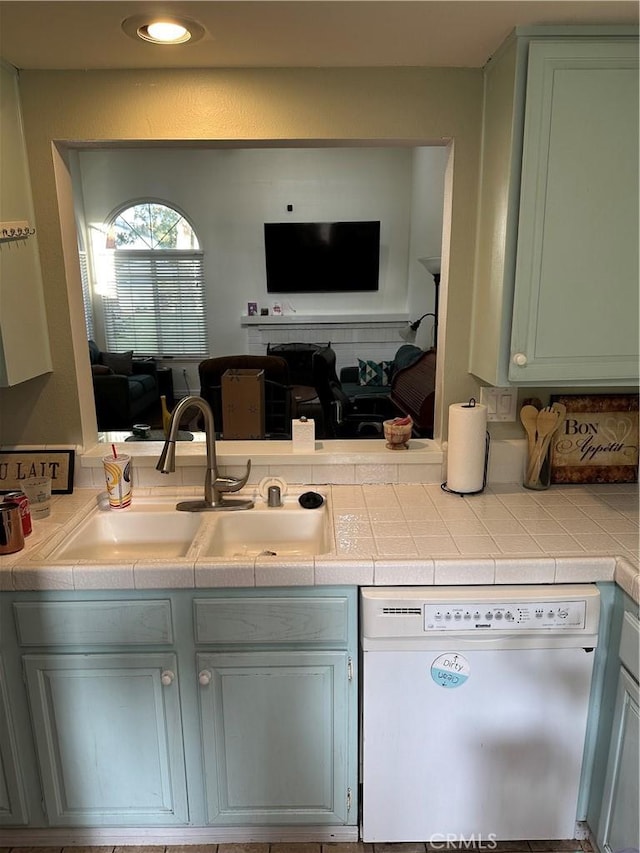 kitchen featuring dishwasher, tile counters, and sink