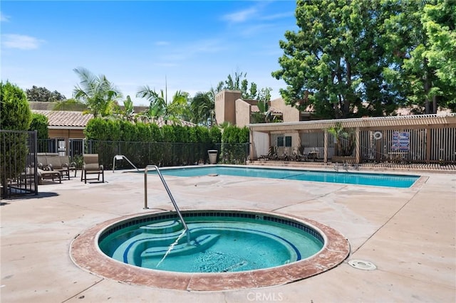 view of pool with a hot tub and a patio