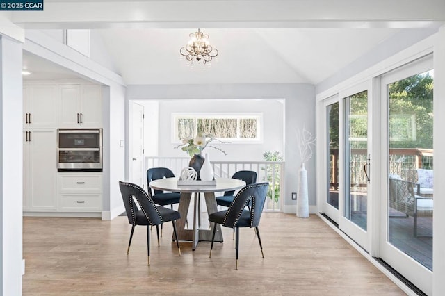 dining space featuring vaulted ceiling, a chandelier, and light hardwood / wood-style flooring