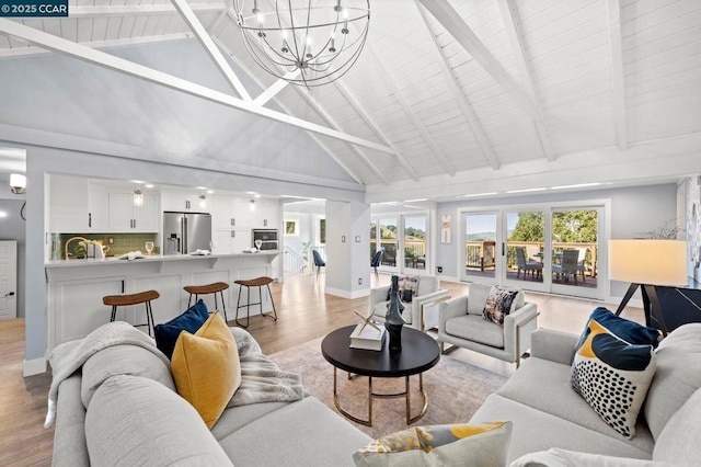 living room featuring high vaulted ceiling, light wood-type flooring, beamed ceiling, and a healthy amount of sunlight