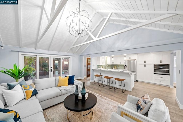 living room with french doors, a notable chandelier, high vaulted ceiling, light hardwood / wood-style flooring, and beam ceiling