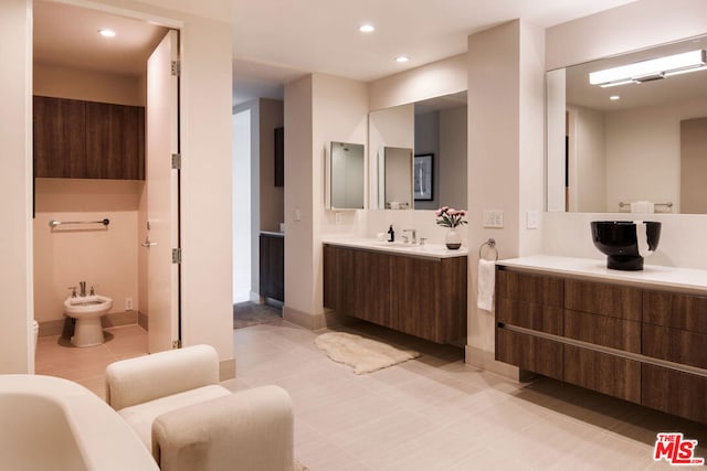 bathroom featuring a tub to relax in, vanity, tile patterned flooring, and a bidet