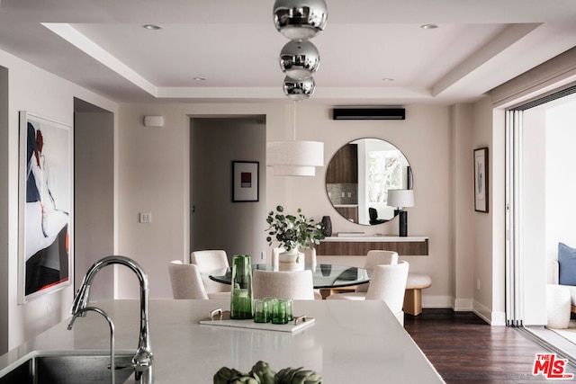 dining room featuring dark hardwood / wood-style flooring, a raised ceiling, and sink