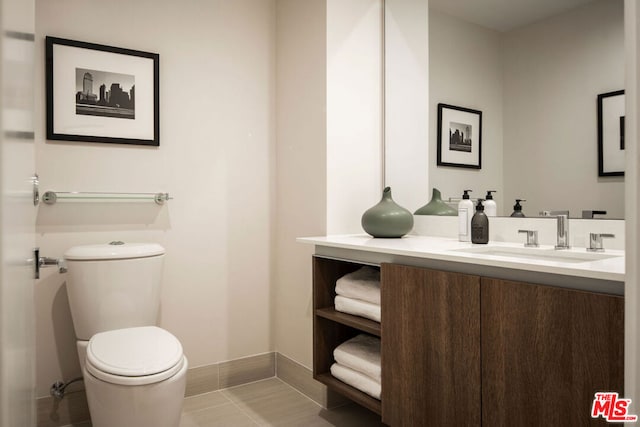 bathroom featuring toilet, vanity, and tile patterned flooring