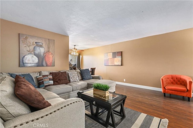 living room featuring ceiling fan and dark hardwood / wood-style flooring