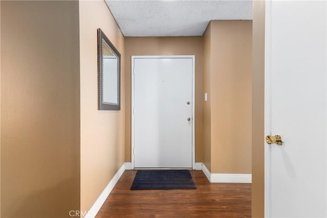 entryway with a textured ceiling and dark hardwood / wood-style flooring