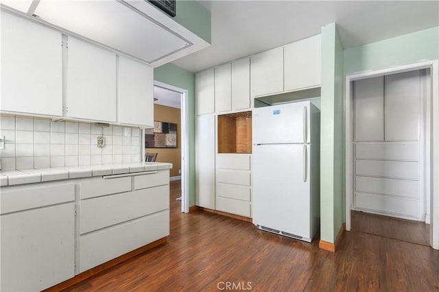 kitchen featuring tile counters, white cabinetry, white refrigerator, tasteful backsplash, and dark hardwood / wood-style floors