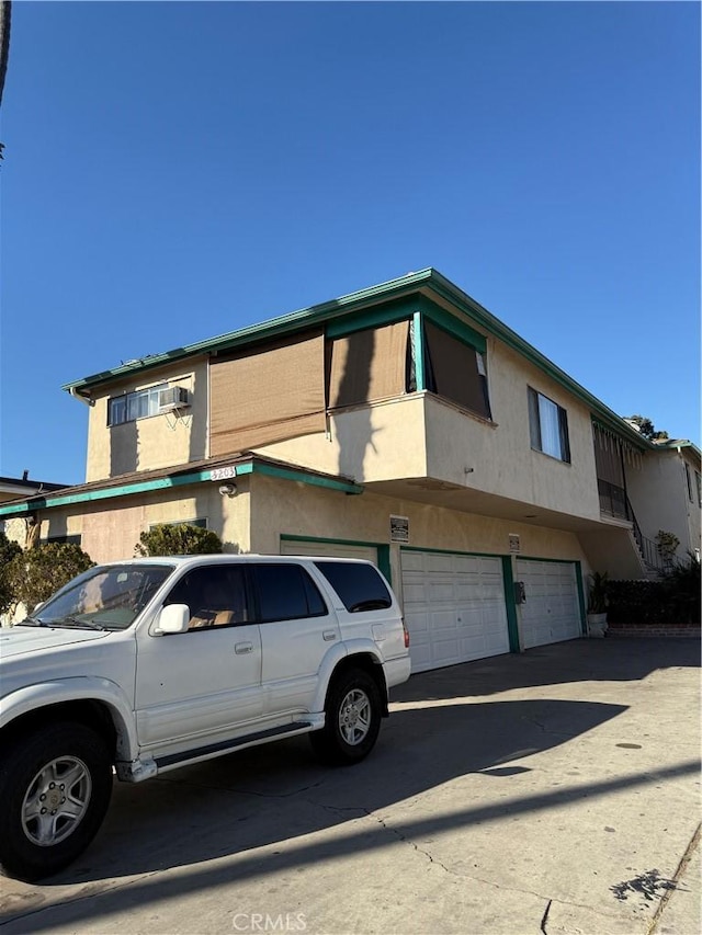 multi unit property with a garage and stucco siding