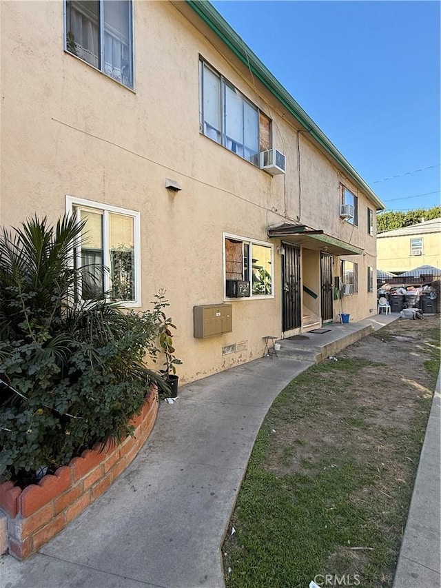 exterior space with cooling unit and stucco siding