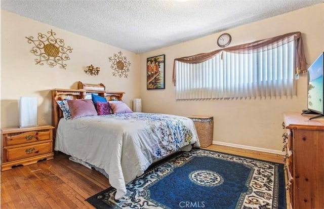 bedroom with wood-type flooring and a textured ceiling