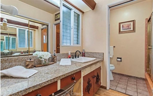 bathroom featuring toilet, walk in shower, hardwood / wood-style floors, and vanity