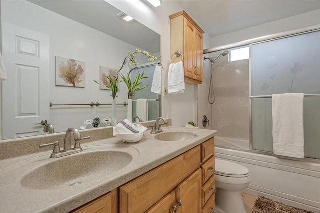 full bathroom featuring shower / bath combination with glass door, vanity, and toilet