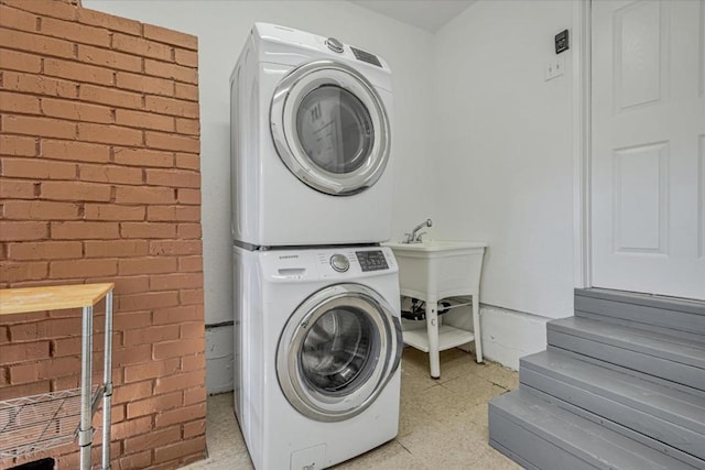 clothes washing area featuring stacked washing maching and dryer