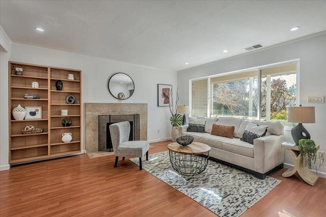 living room with hardwood / wood-style flooring and a tile fireplace