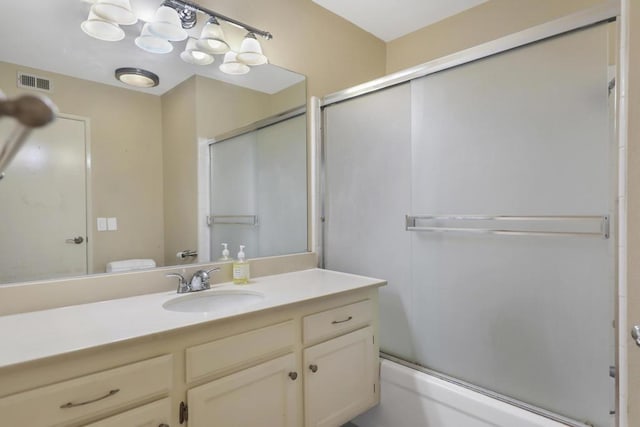 full bathroom featuring toilet, bath / shower combo with glass door, and vanity