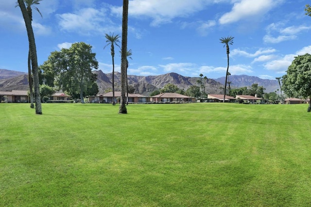 surrounding community with a mountain view and a yard