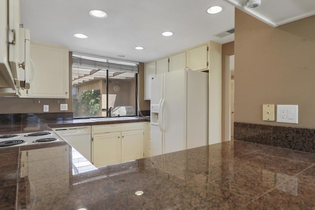 kitchen with sink, cream cabinets, and white appliances