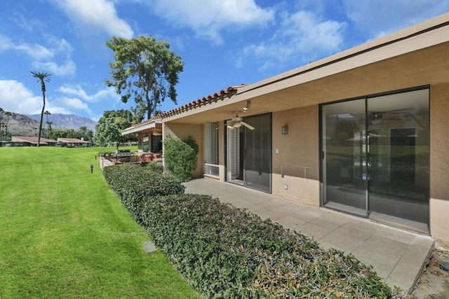 view of yard featuring a patio area, ceiling fan, and a mountain view