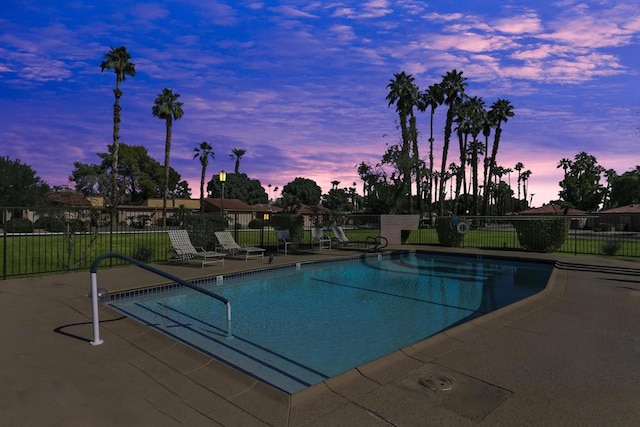 pool at dusk featuring a patio area