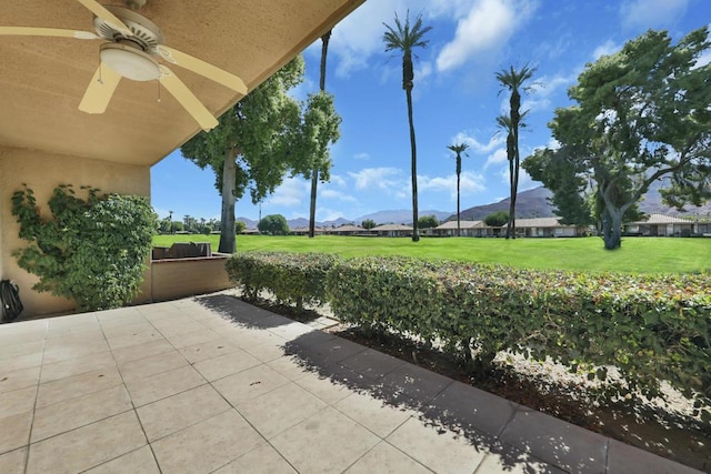 view of patio / terrace featuring ceiling fan and a mountain view